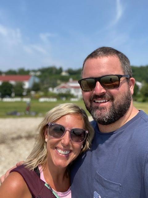 Nicole Greiner smiling happily with her partner for a selfie on a sunny day